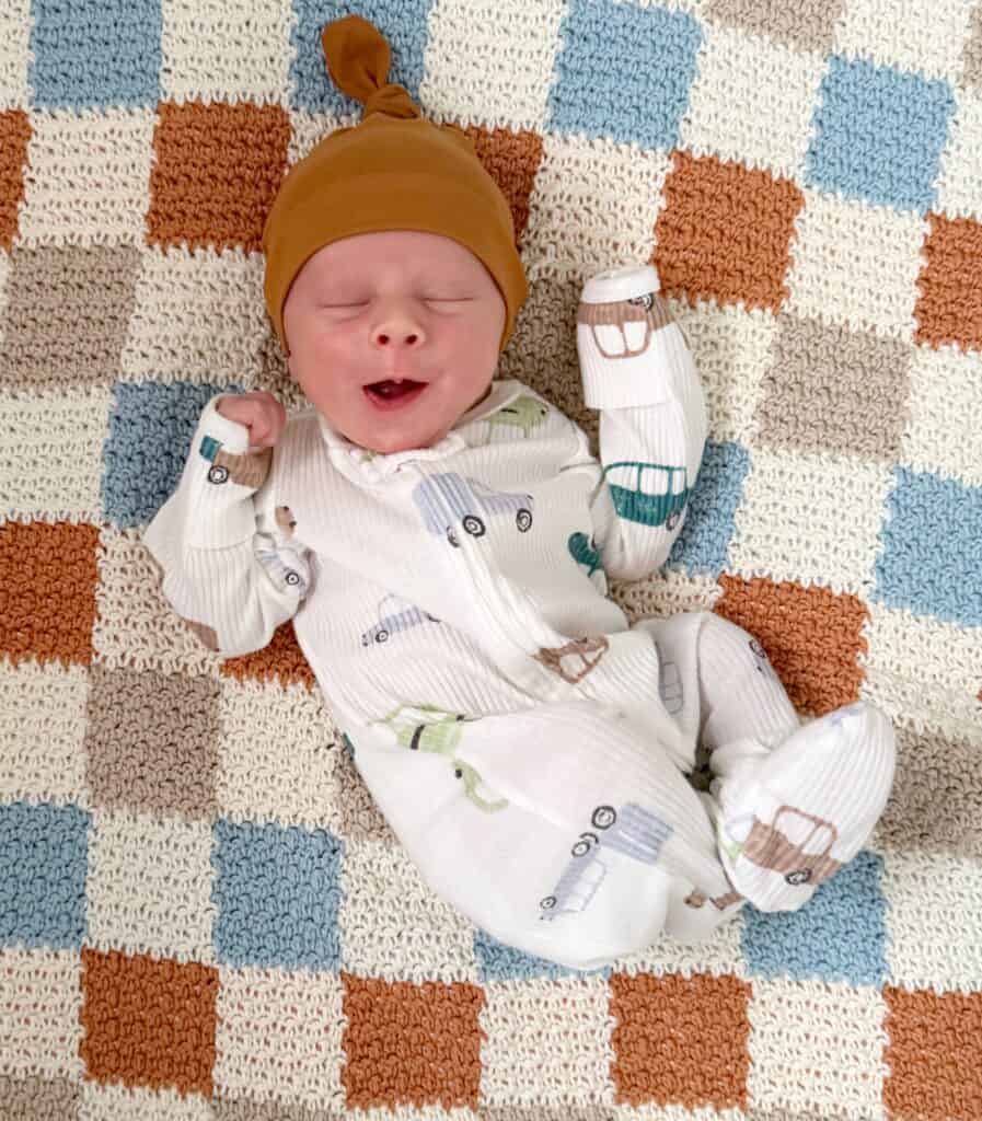 baby boy laying on checkered crochet blanket