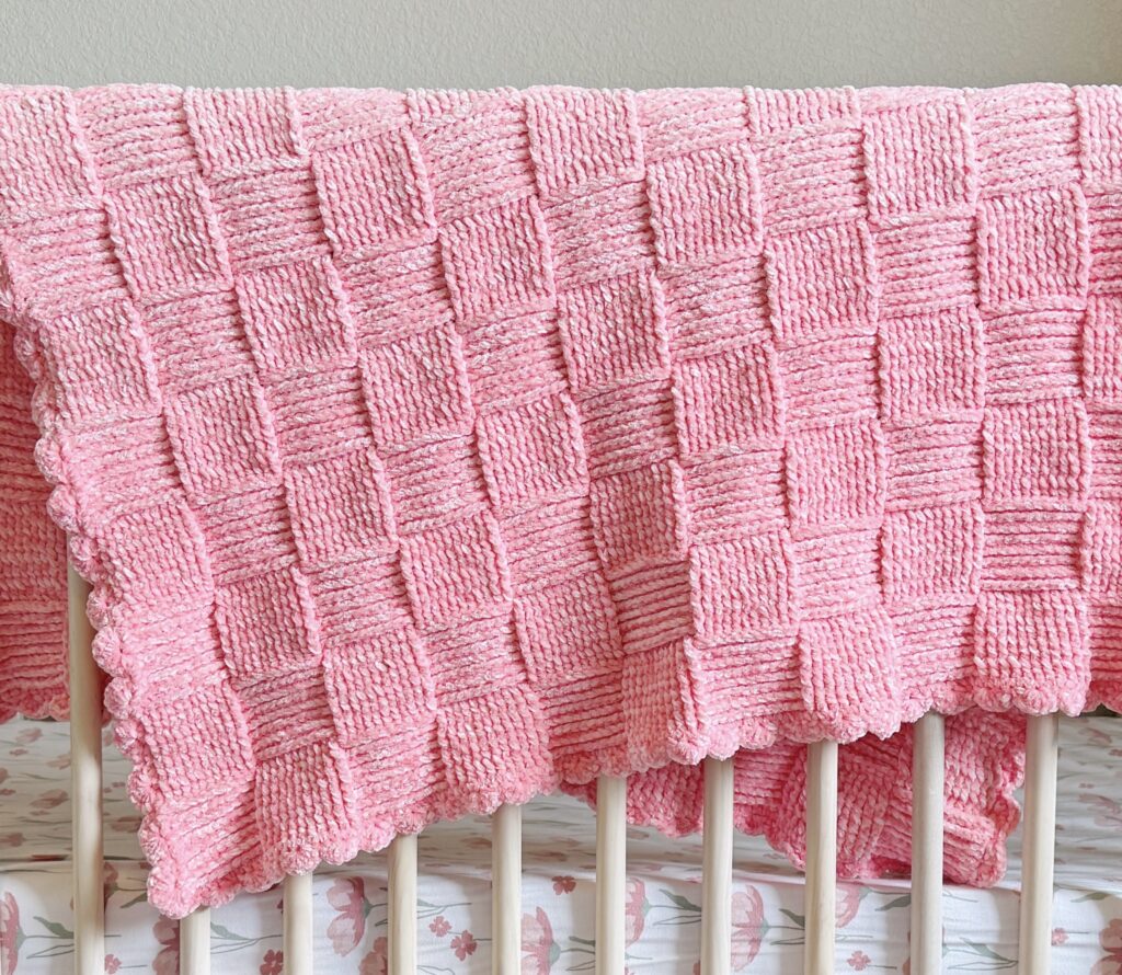 pink crochet basket draped over crib